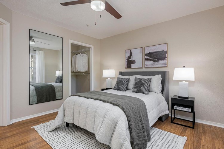 Spacious bedrooms featuring wood-style flooring, walk-in closets, and a multi-speed ceiling fan.