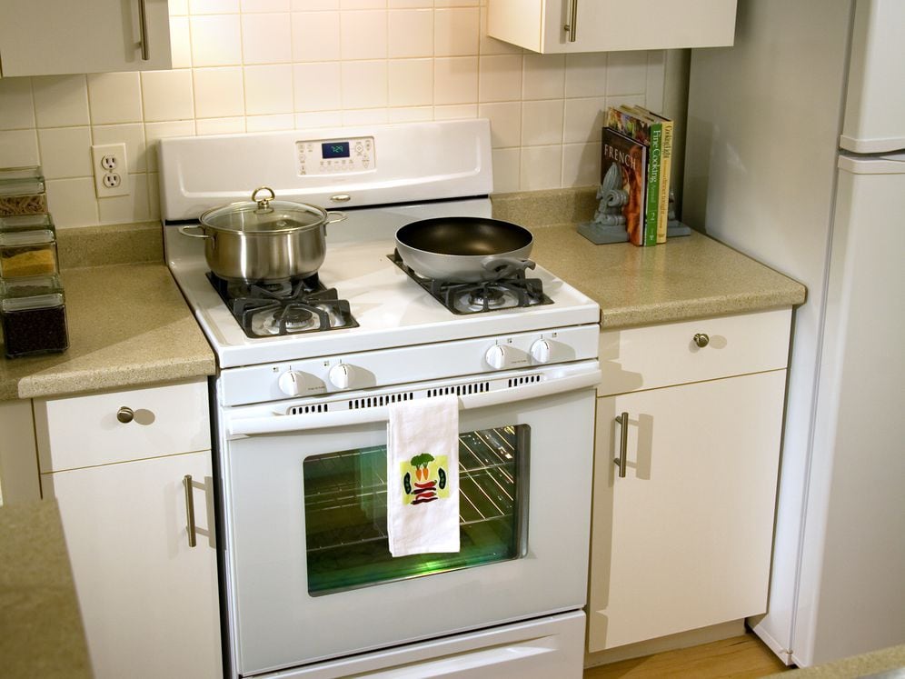 Classic Package kitchen with white cabinetry, laminate countertops, hard surface flooring, white appliances, and white tile backsplash