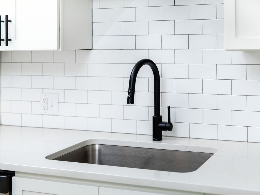 Kitchen with white quartz countertops and tile backsplash