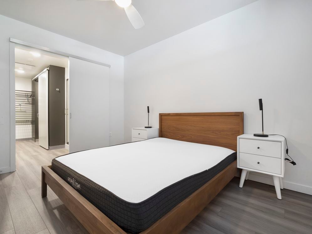 Furnished+ apartment homes feature queen bed with mattress, dresser, nightstands, and lamps (Representative Image – exact items and style of furnishings may vary)