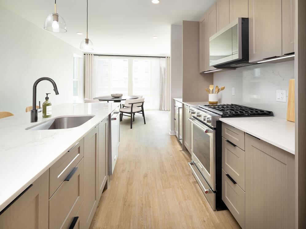 Signature Collection Kitchen with oak shaker cabinetry, marbled white quartz countertop and backsplash, and upgraded stainless steel appliances