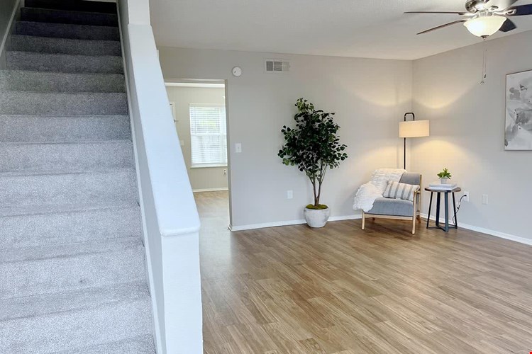 Fabulous, spacious living space to unwind at the end of your day featuring wood-style flooring and a ceiling fan.