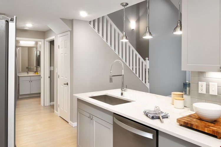 Premier Finish kitchen with grey cabinetry, white quartz countertops, stainless steel appliances, and hard surface flooring