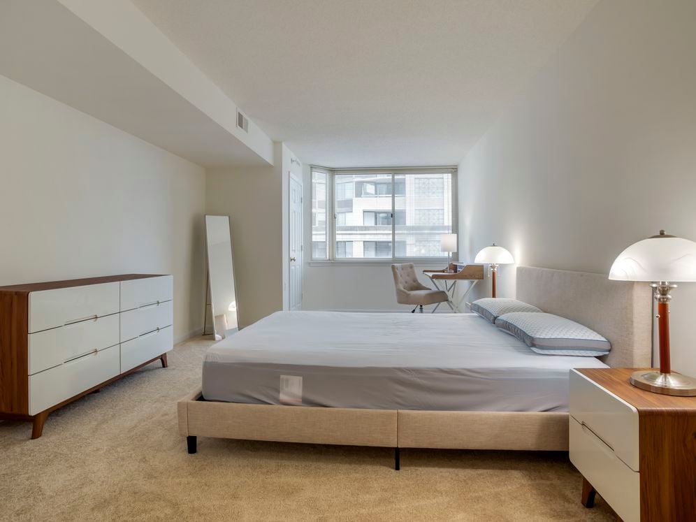 Furnished+ apartment homes feature queen bed with mattress, two pillows, dresser, nightstands, lamp, and mirror. (Representative Image – exact items and style of furnishings may vary)