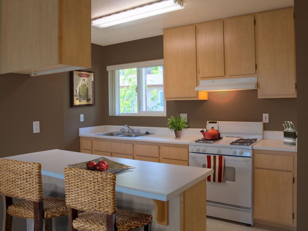 Classic Package I kitchen with oak cabinetry, white laminate countertops, white appliances, and hard surface flooring