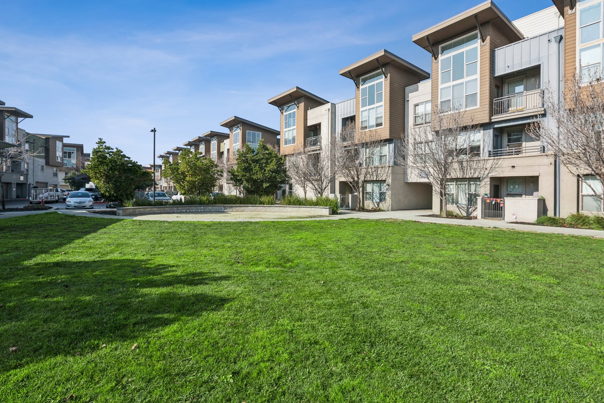 Aspire Apartments Tracy California Luxury Living Apartment complex with a fountain in the middle of a grassy area.