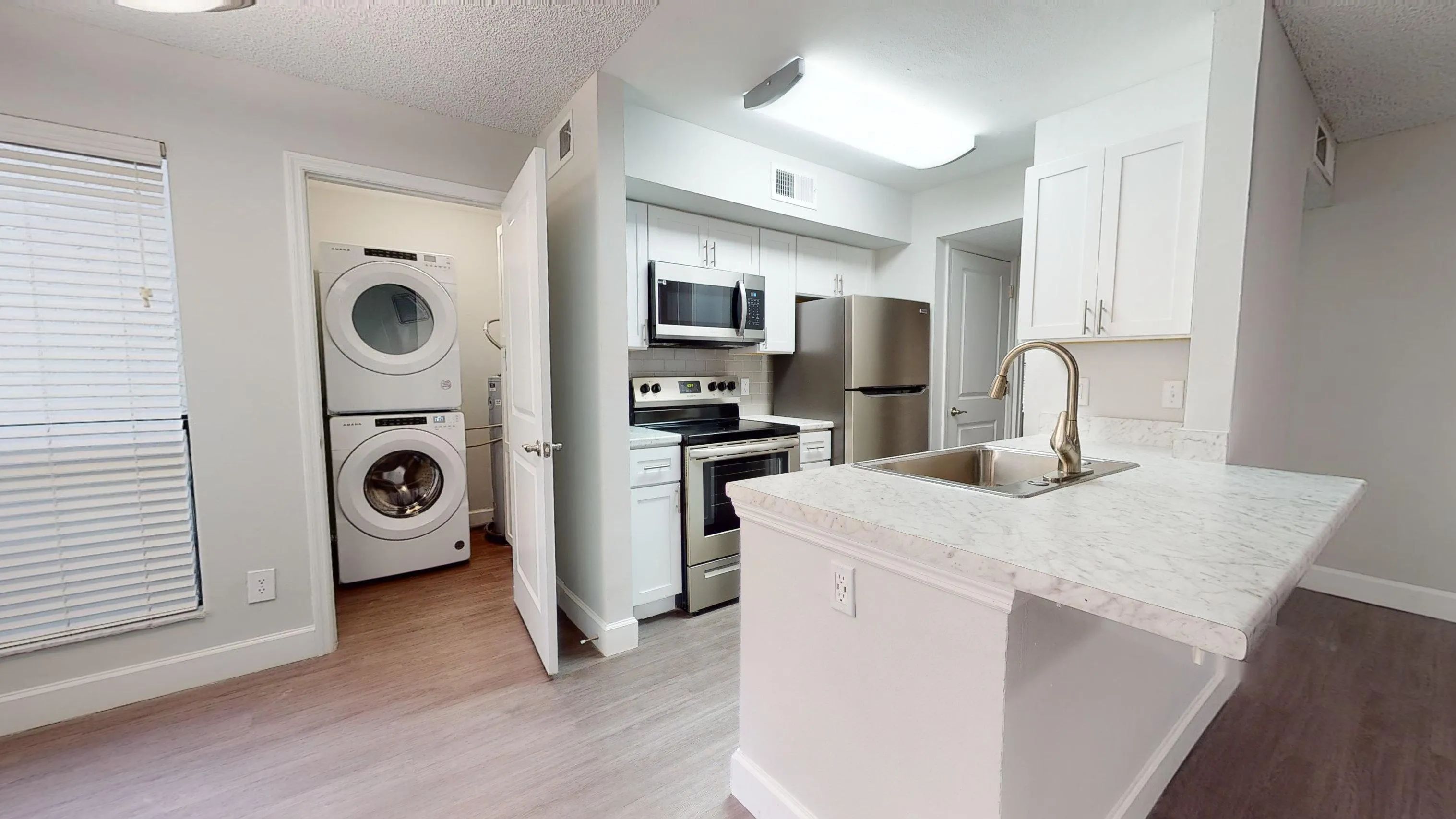 The Martinique floor plan offers a sleek kitchen with stainless steel appliances and an laundry area with a full-size washer and dryer, designed for your convenience.