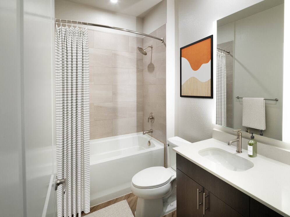 Bath with quartz countertop, tile backsplash, and hard surface flooring