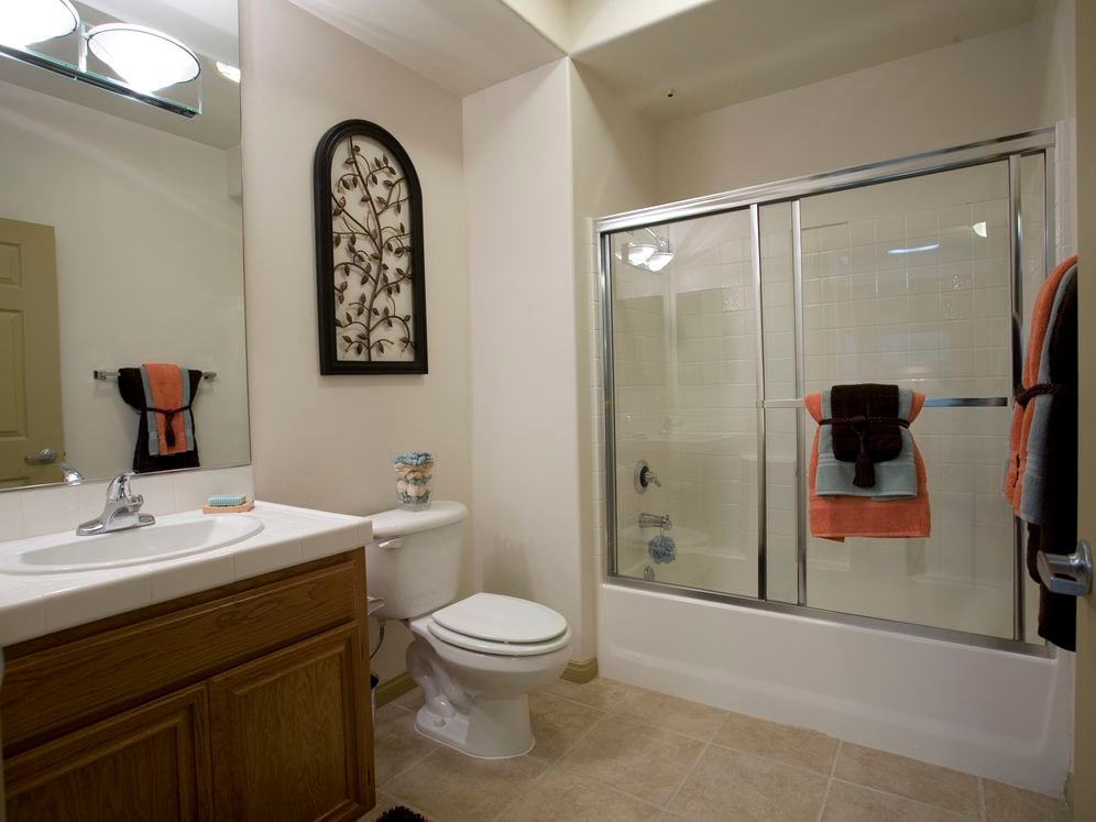 Classic Package I bath with white tile countertop, oak cabinetry, and tile flooring