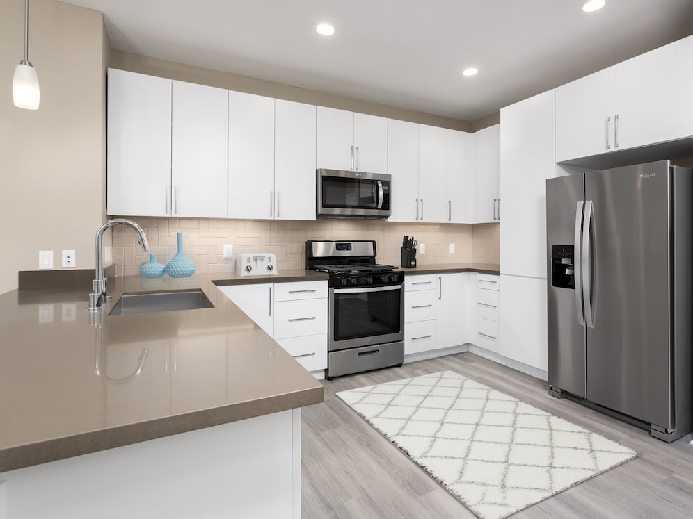 Newly renovated Design Scheme I kitchen with new cabinets, quartz countertops, stainless steel appliances, and hard surface plank flooring