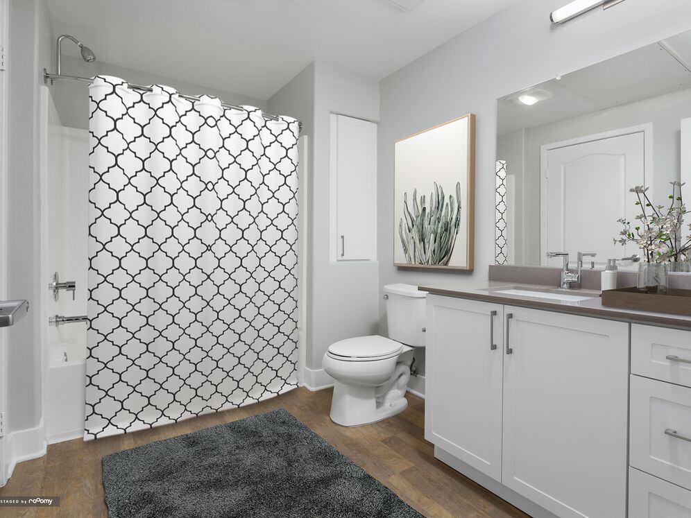 Renovated Package I bath with white cabinetry, grey quartz countertop, and hard surface flooring