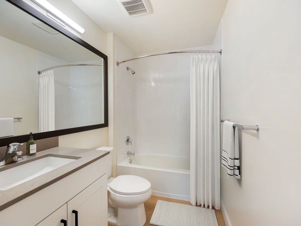 New Apartments bath with grey quartz countertop, white cabinetry, and hard surface flooring