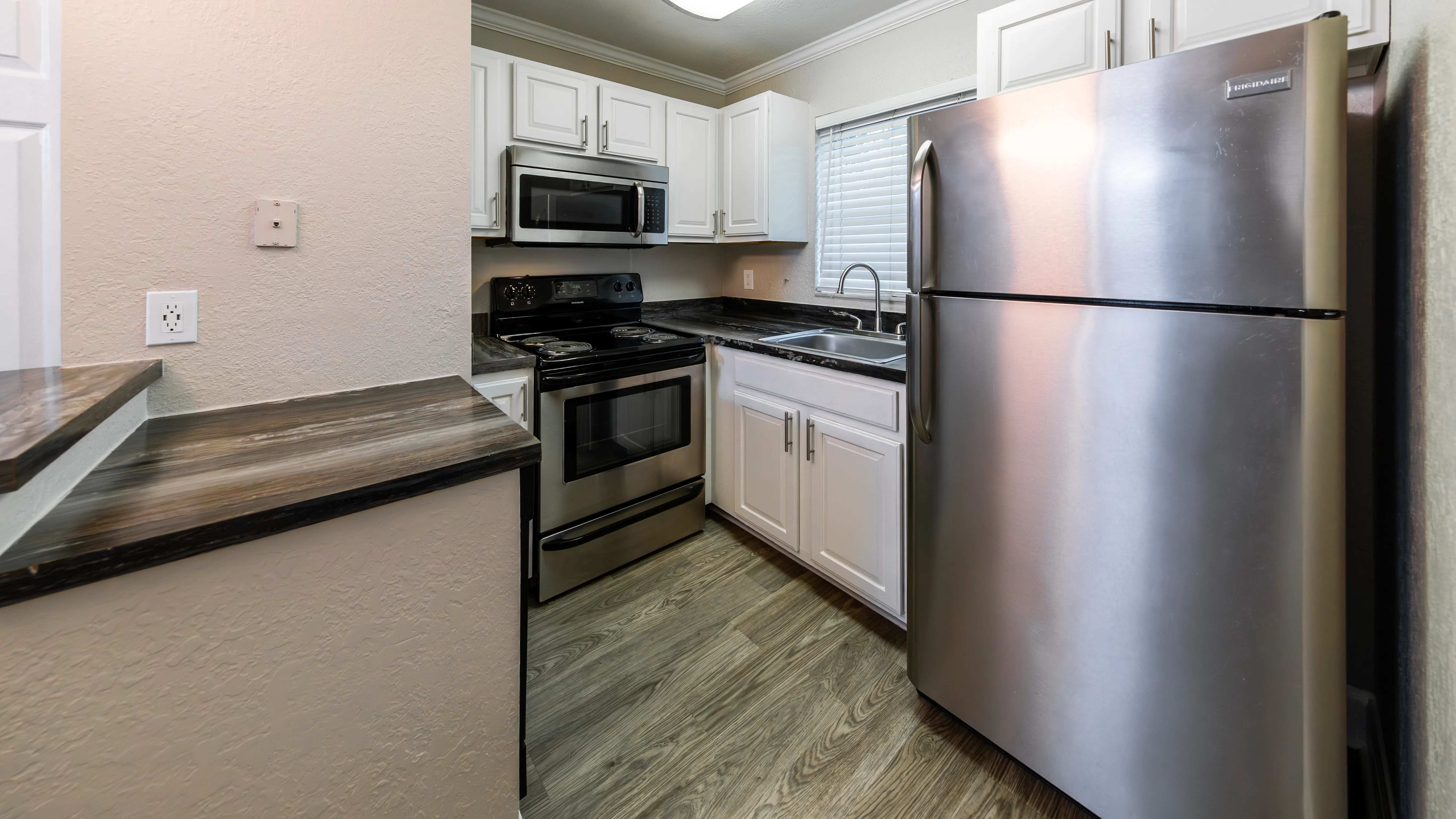 Discover culinary delight in a kitchen with stainless-steel appliances, black fusion countertops, and a convenient USB outlet, combining functionality with timeless charm.