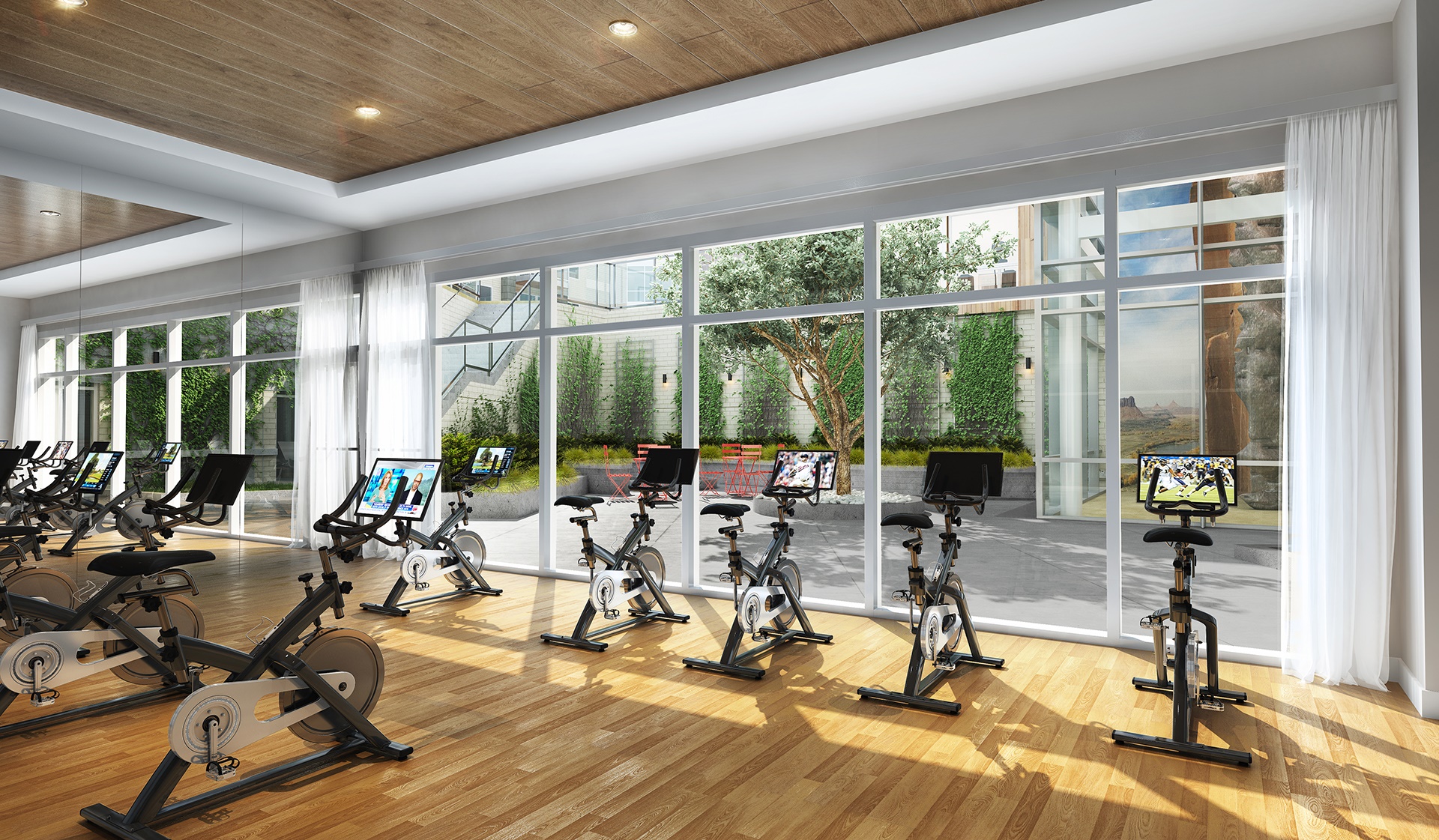 Two-story fitness center with Peloton bikes and yoga studio