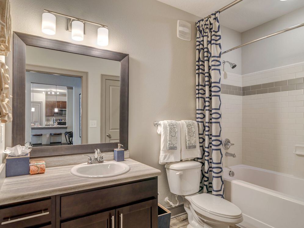 Bath with wood cabinetry and hard-surface flooring