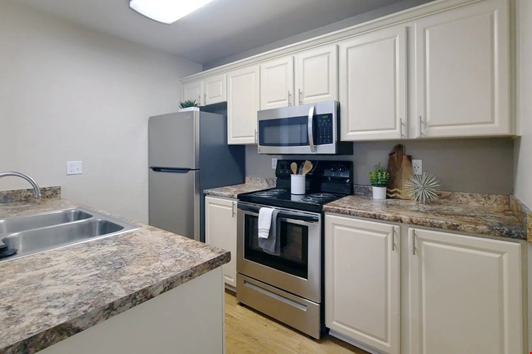 Kitchen magic with granite-style countertops, wood-style floors, and cabinets galore.