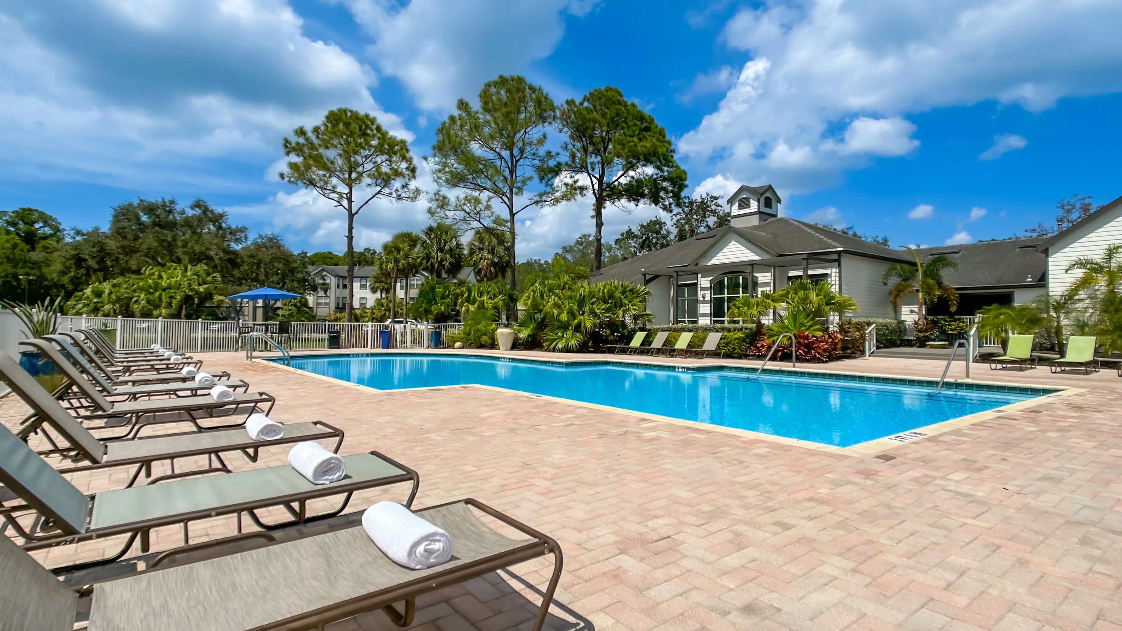 Loungers, umbrellas, and a lakeside backdrop create the ultimate pool experience in sunny Bradenton!