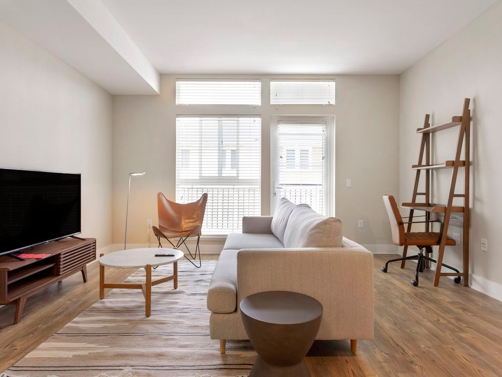 Furnished+ apartment homes come outfitted with a sofa, side chair, side table, coffee table, office chair, desk, TV stand and 50" Television (Representative Image – exact items and style of furnishings may vary)