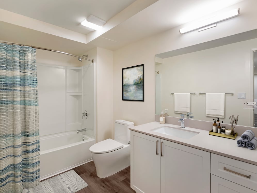 Bath with beige quartz countertops, white cabinetry, and hard surface flooring (Select Home)