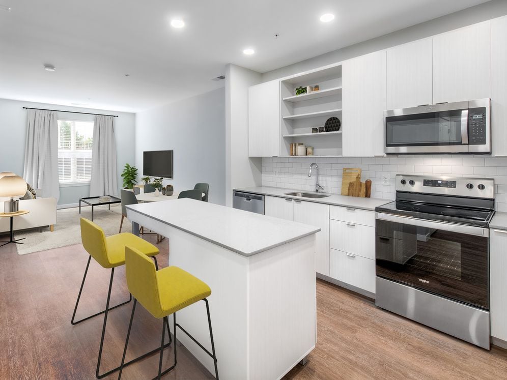 Kitchen with quartz stone countertops and white cabinetry with tile backsplash on hard surface flooring