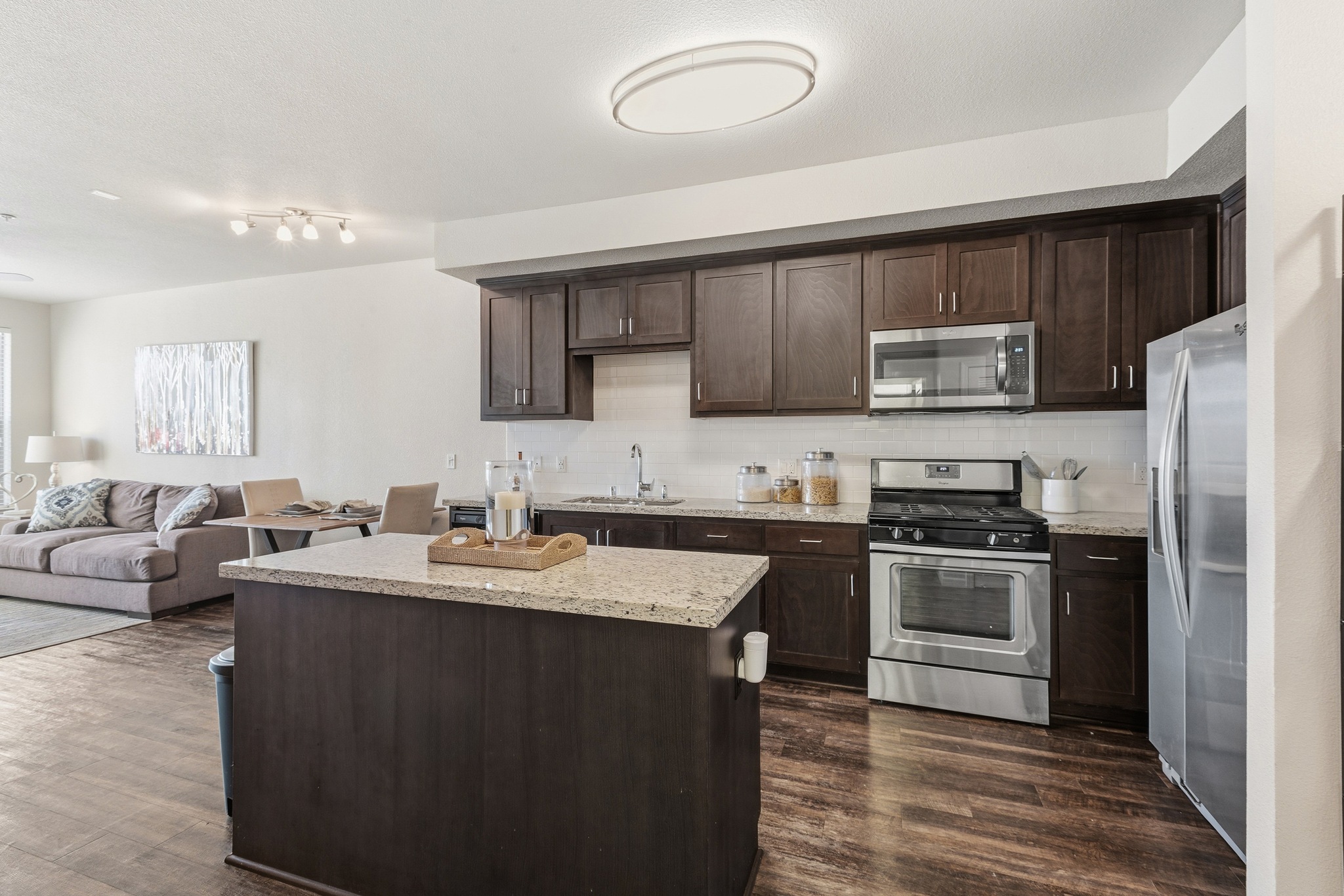 Aspire Apartments Tracy CA A modern kitchen with dark wood cabinets and stainless steel appliances.