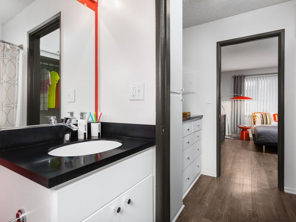 Classic Package II bath with black laminate countertops, white cabinetry, and hard surface flooring