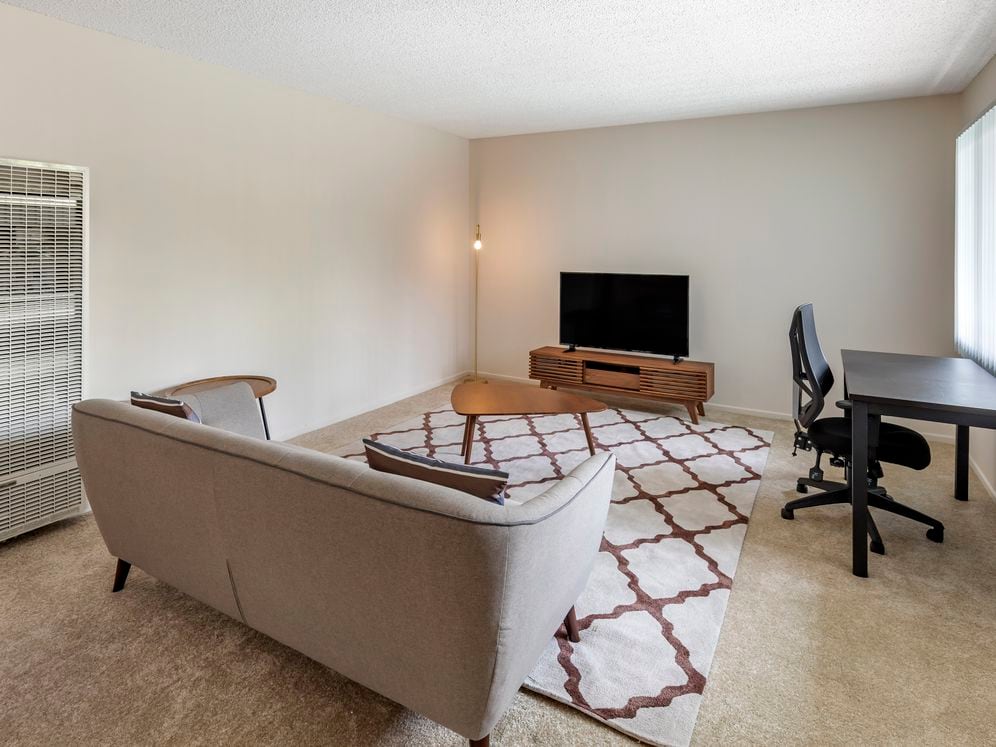 Furnished+ apartment homes come outfitted with a sofa, side chair, side table, coffee table, TV stand and 50" Television (Representative Image – exact items and style of furnishings may vary)