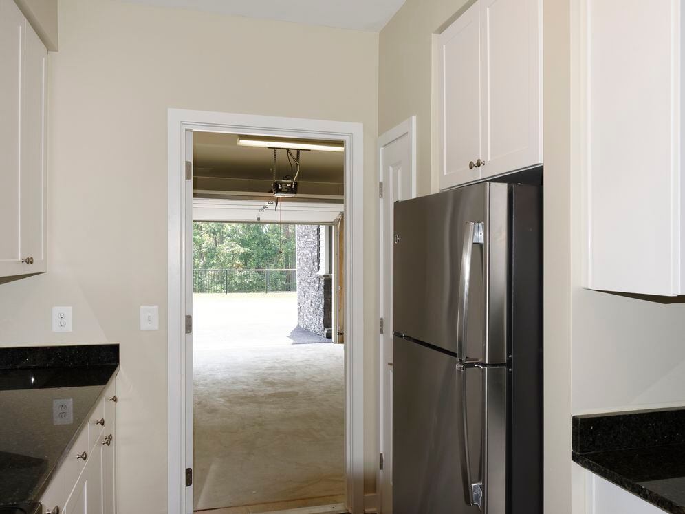 Open concept kitchen with white shaker cabinetry, granite countertops, kitchen island, stainless steel appliances and hard surface flooring