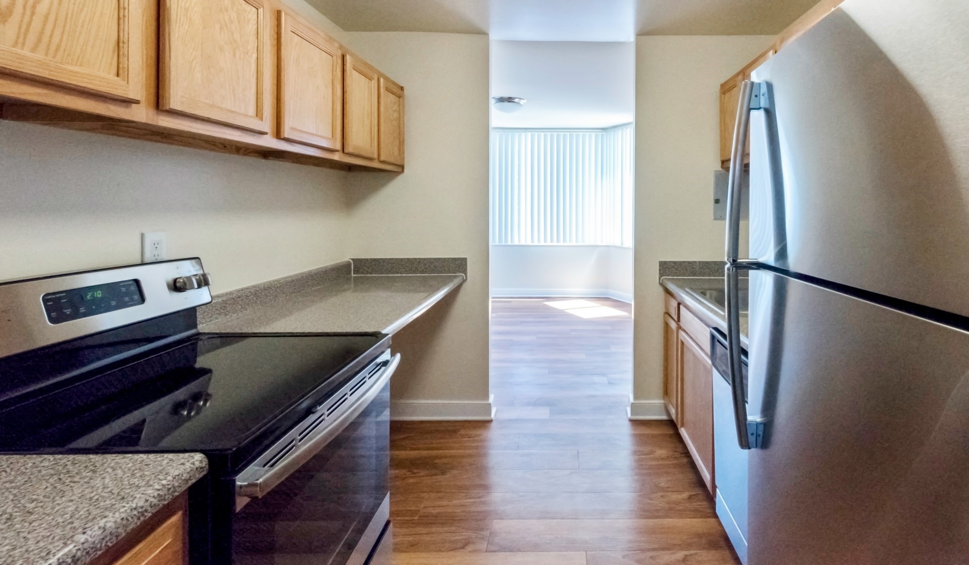 Stainless steel appliances and wood plank flooring in the kitchen