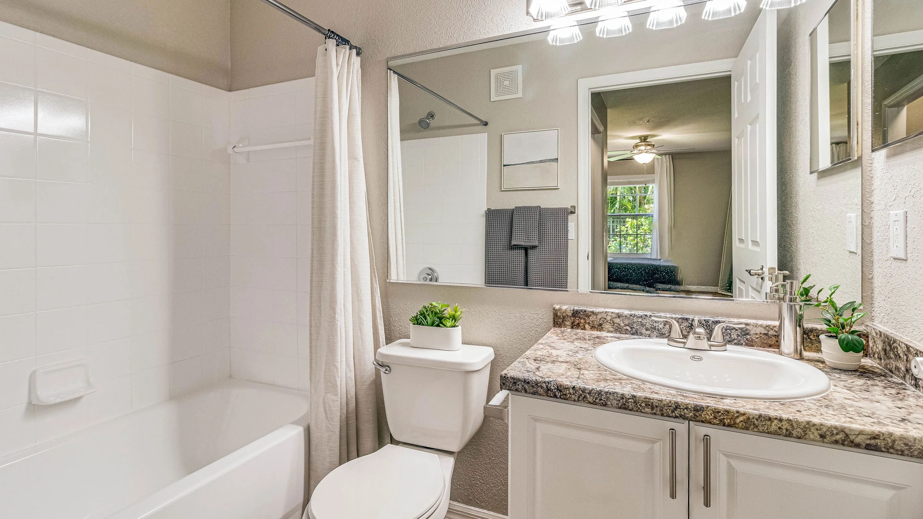 Experience bright bathrooms adorned with large mirrors and radiant vanity lighting.