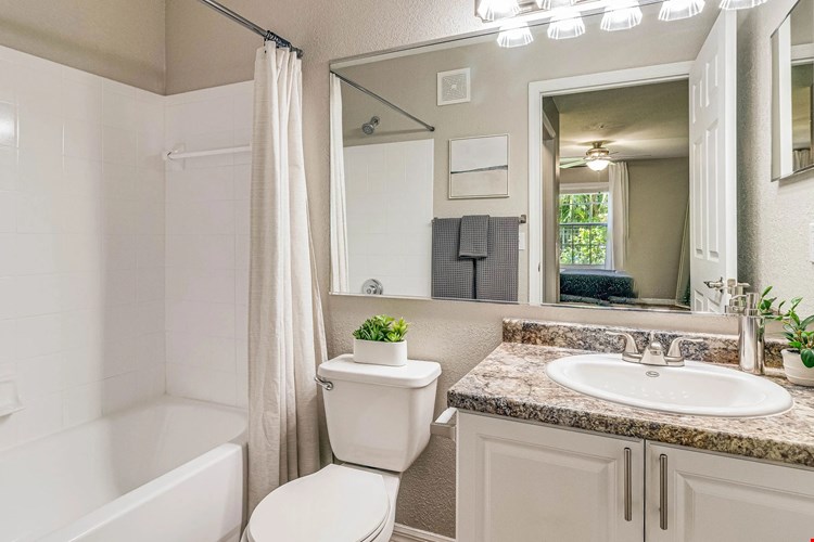 Experience bright bathrooms adorned with large mirrors and radiant vanity lighting.