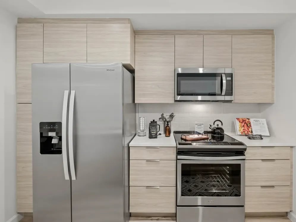 West Phase Kitchens with oak cabinetry, white countertops, and stainless steel appliances