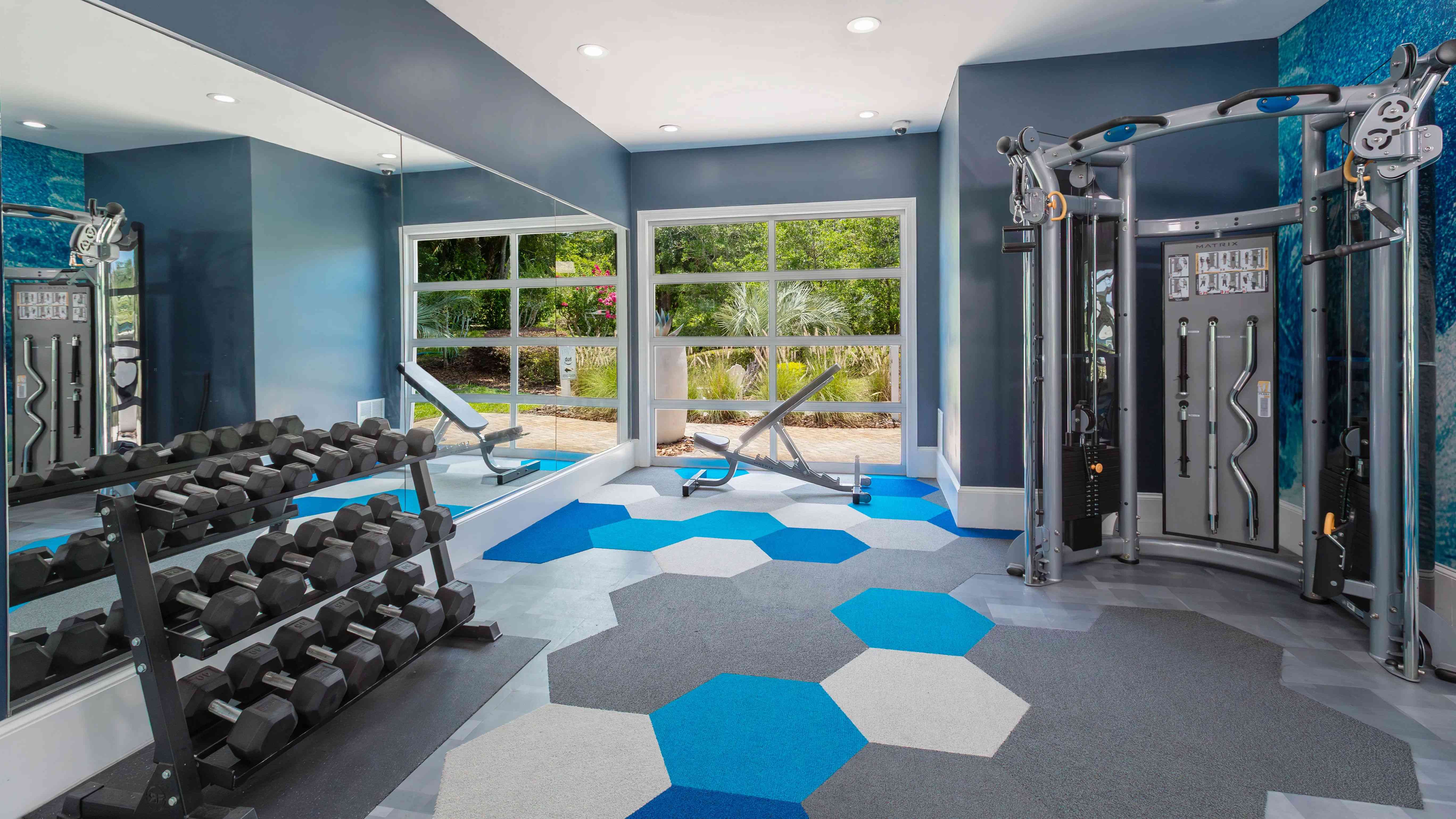Elevate your wellness routine in our modern fitness center, featuring strength training equipment, free weights, and energizing natural light.
