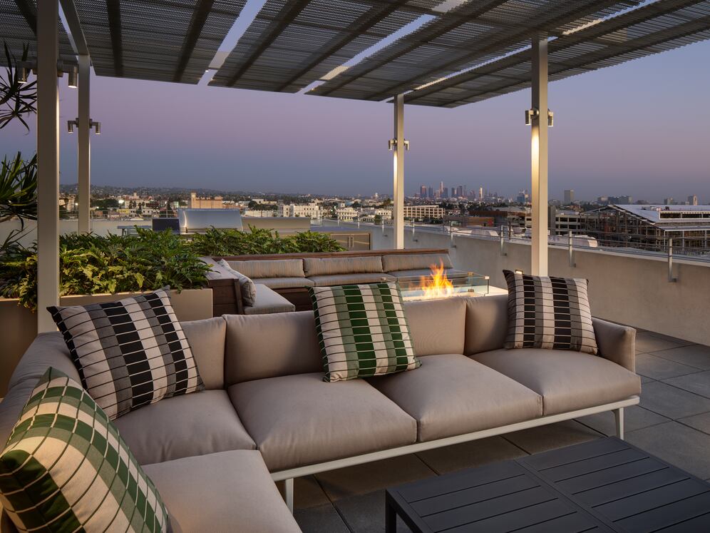 Roofdeck at dusk with outdoor fireplace, lounge seating and panoramic views