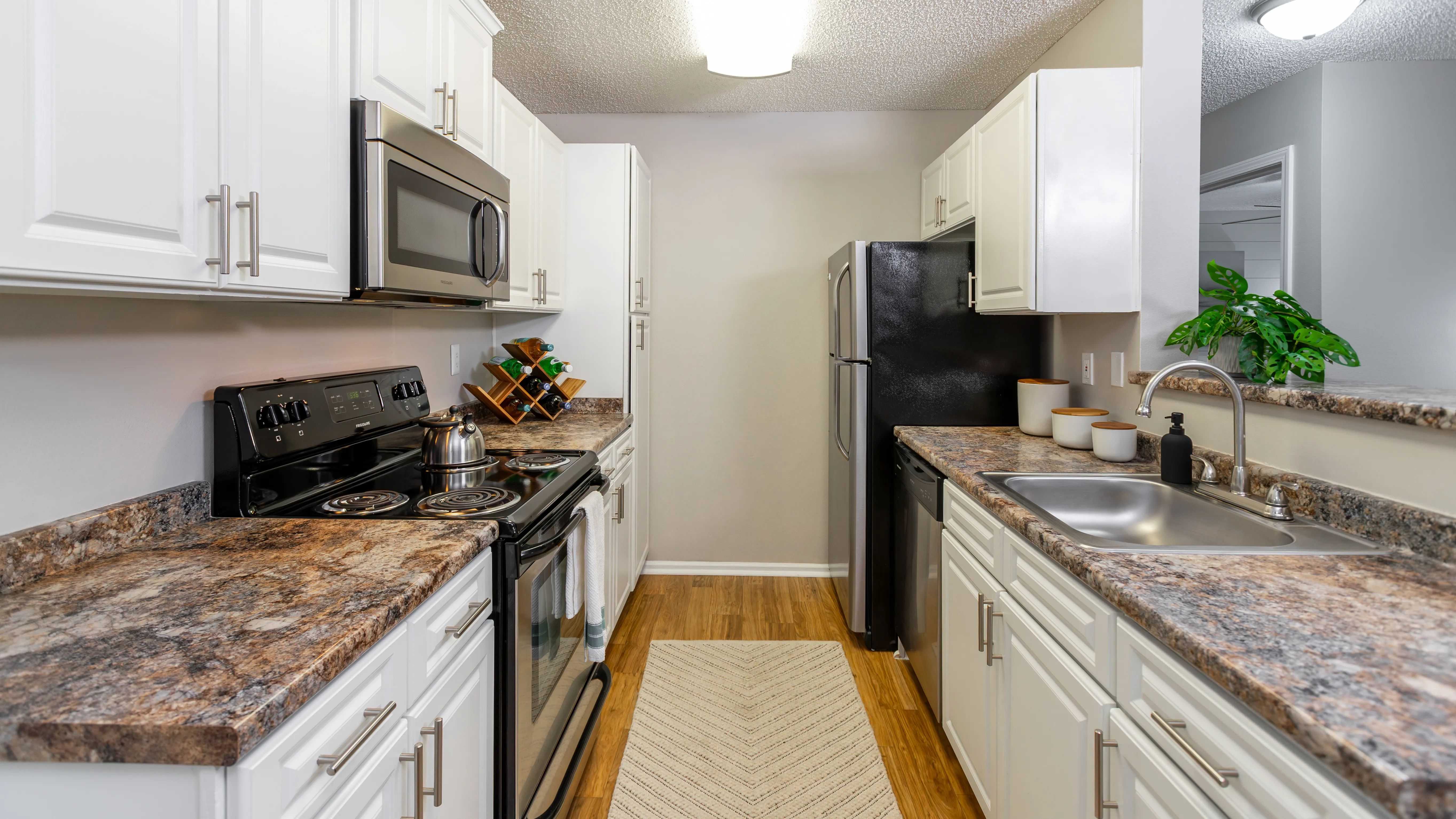 Enjoy cooking in a fully equipped kitchen with sleek stainless appliances, granite-inspired counters, and bright white cabinetry for a clean, modern look.