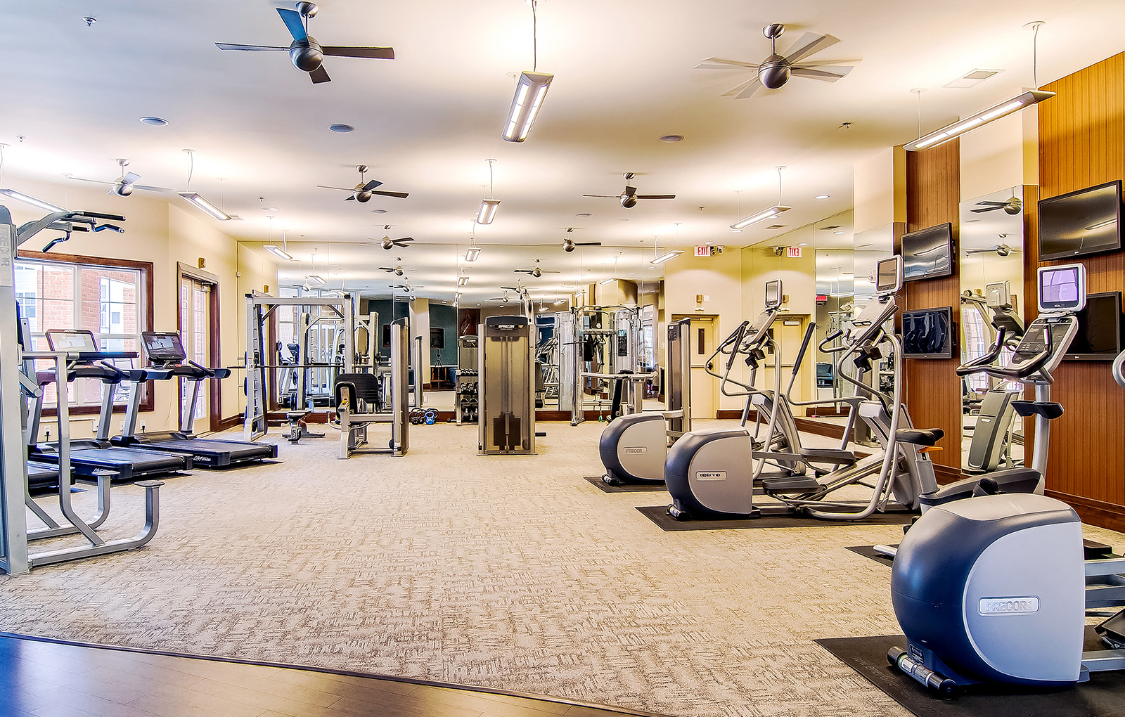 Expansive Fitness Center with Interactive TV Monitors Overlooking Pool