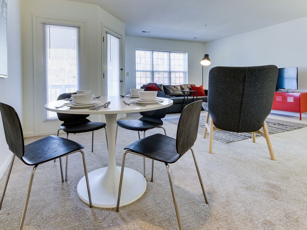 Carpeted living and dining area with balcony access