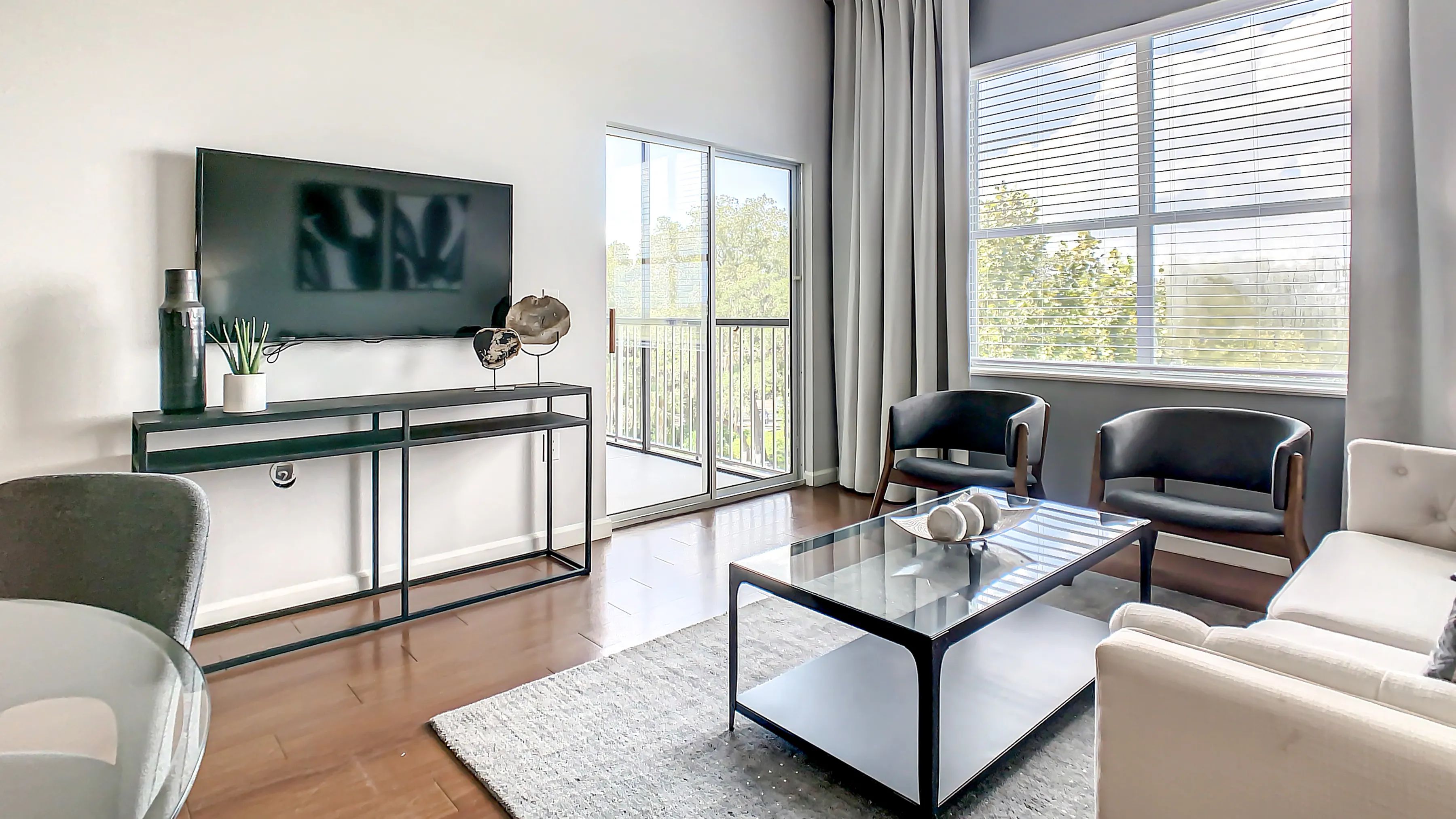 Delight in the timeless elegance of your airy living room inviting natural light indoors through large windows and sliding patio doors leading to your private balcony or patio.