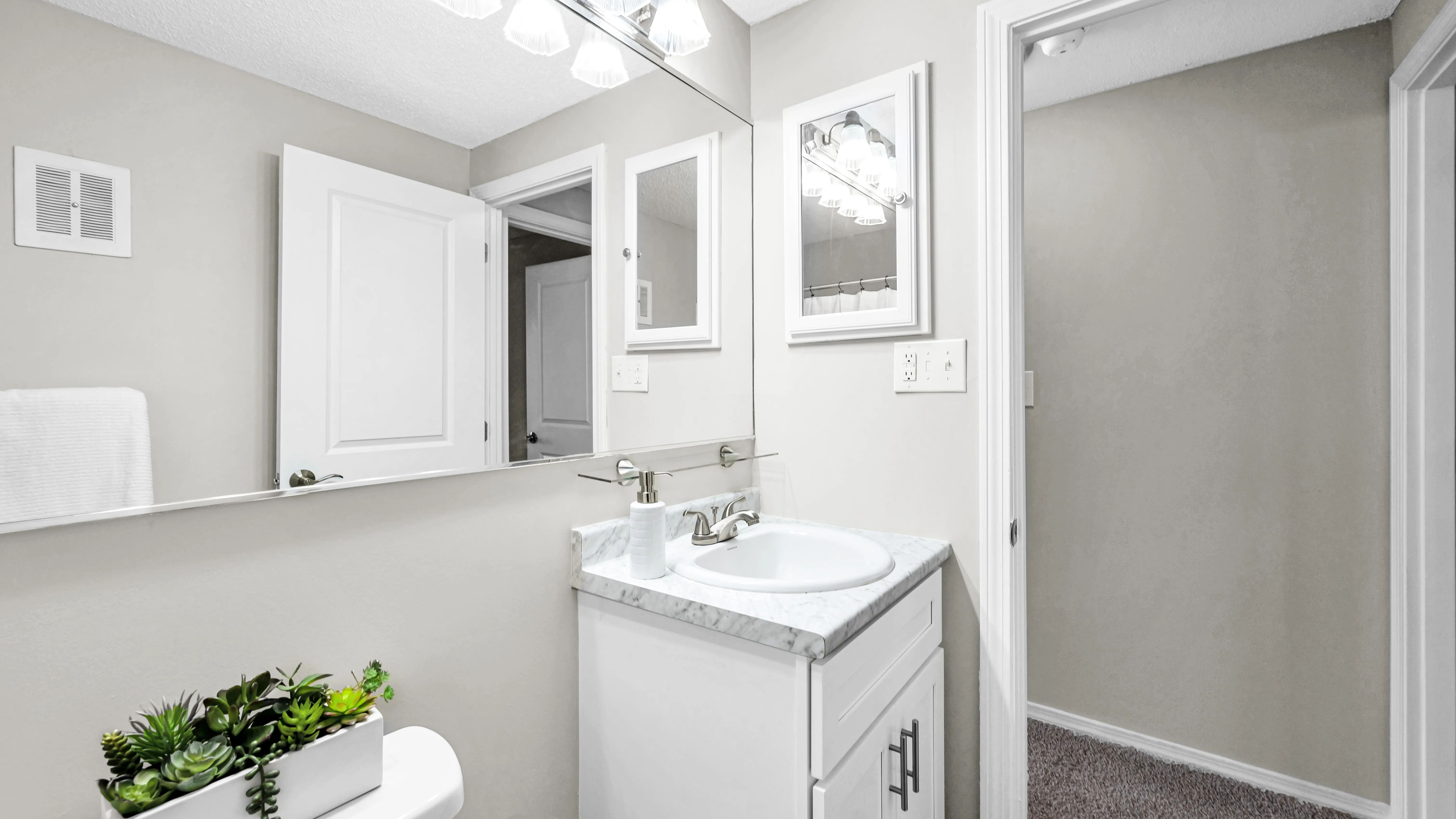 Our bathrooms are elegantly remodeled, featuring expansive mirrors and exuberant vanity lighting that exude timeless elegance. 