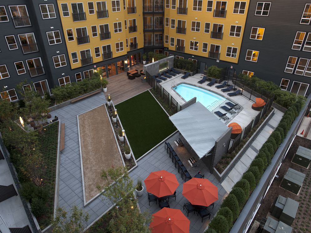 Courtyard with swimming pool and sundeck with lounge seating, greenspace
